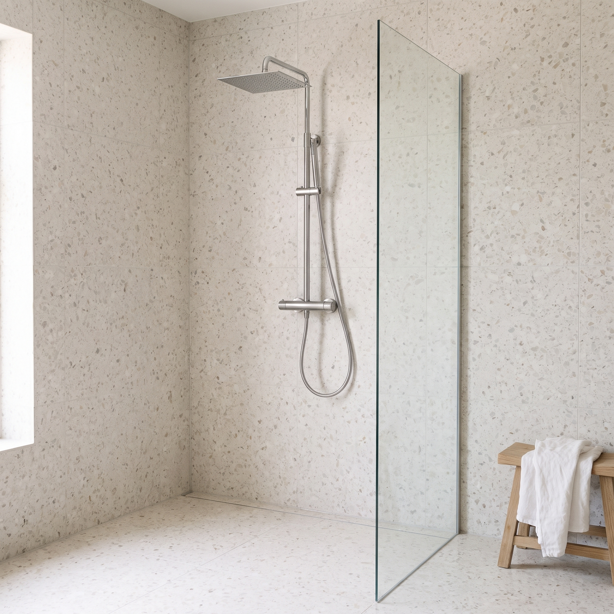 Colonne de douche thermostatique carrée chrome poli Anthéor installée dans une douche à l'italienne en terrazzo