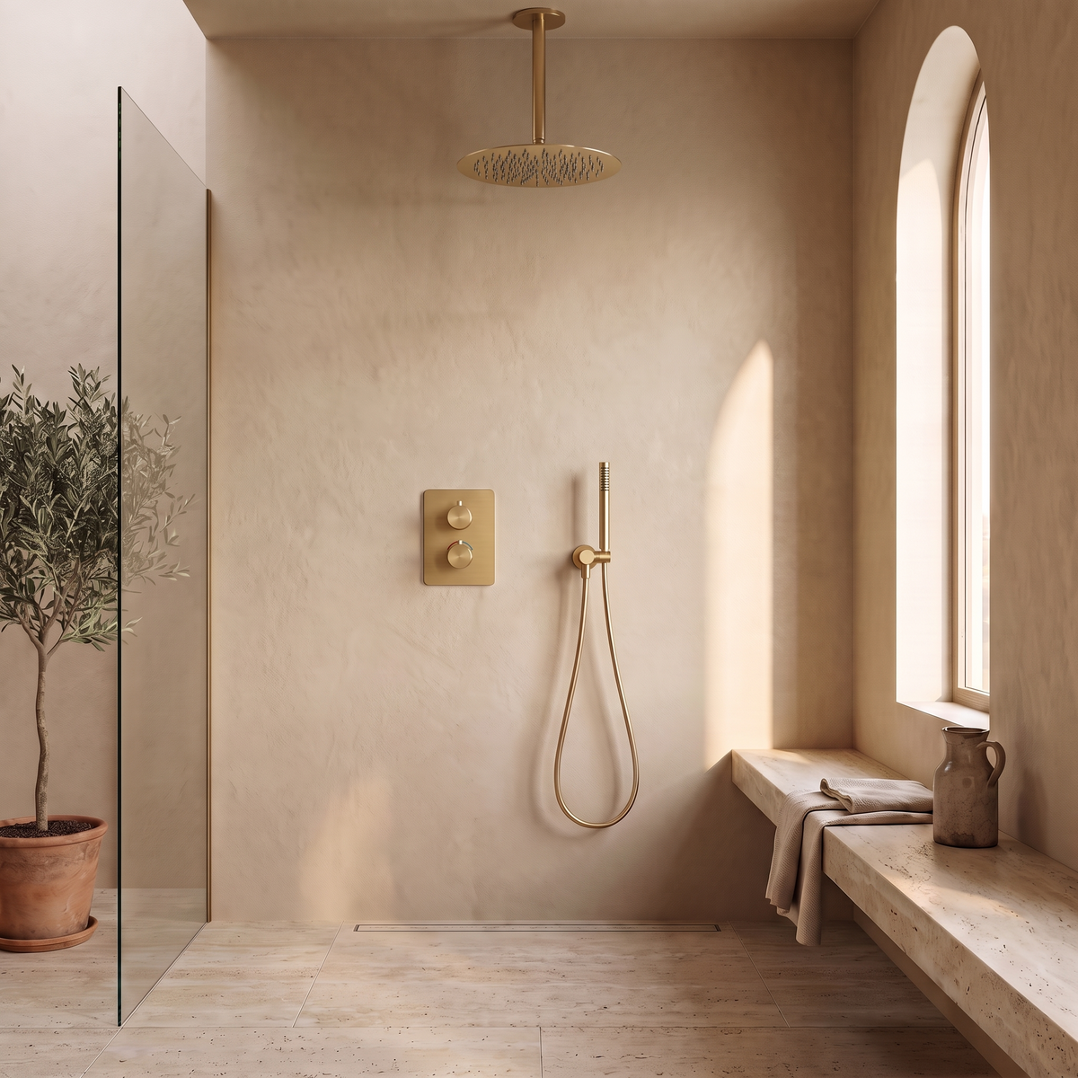 Colonne de douche encastrable plafond suspendu or brossé Estérel dans une douche à l'italienne en enduit sable et travertin